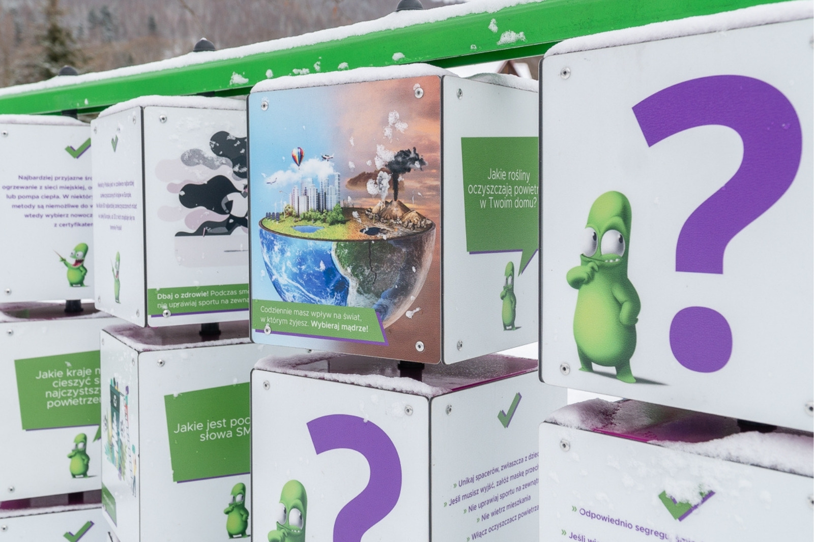 Smogo memory - zbliżenie kostek: zielone dymki z pytaniami o powietrze oraz ilustracja Ziemi w połowie zadymionej, w połowie czystej