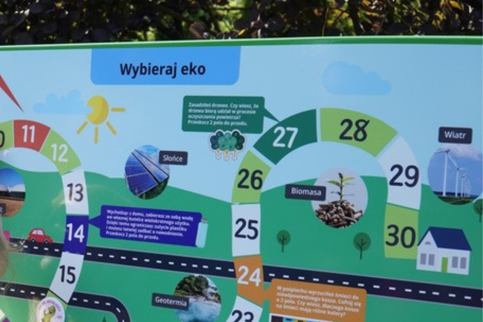 Tablica z grą EKO - prawa część planszy „Wybieraj eko” z dymkami przy polach 24 i 27 oraz domem na końcu ścieżki